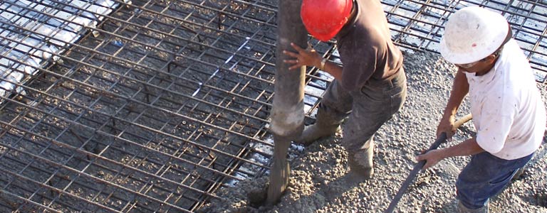 Workers pouring cement on Matching Rebar Deck